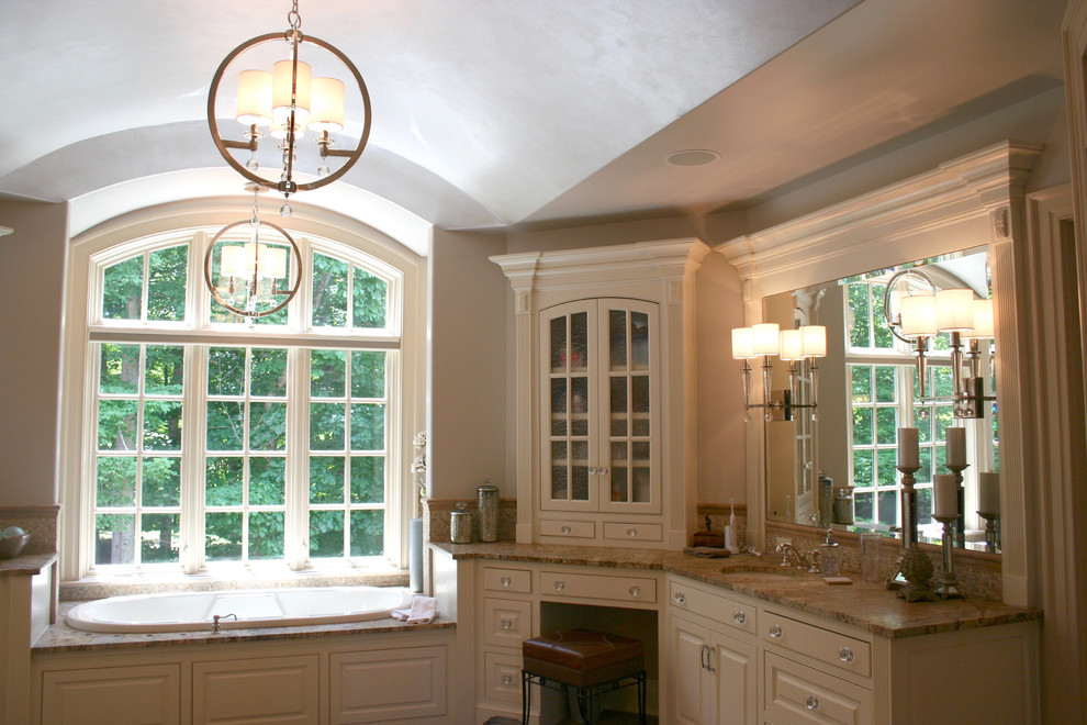 Mid-sized transitional master beige tile alcove bathtub photo in Columbus with raised-panel cabinets, beige cabinets, beige walls, an undermount sink and granite countertops