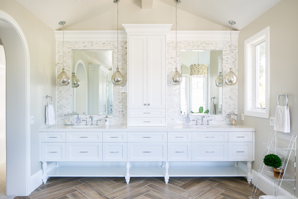 Design ideas for a transitional bathroom in Orange County with recessed-panel cabinets, white cabinets, gray tile, white tile, mosaic tile, brown floor and white benchtops.