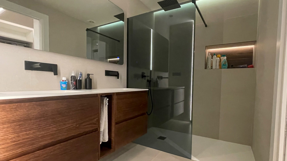 Photo of a large modern master bathroom in Valencia with brown cabinets, a curbless shower, gray tile, marble, grey walls, laminate floors, a wall-mount sink, quartzite benchtops, grey floor, white benchtops, a single vanity and a floating vanity.