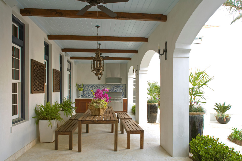 Photo of a large mediterranean backyard verandah in Miami with an outdoor kitchen, a roof extension and tile.