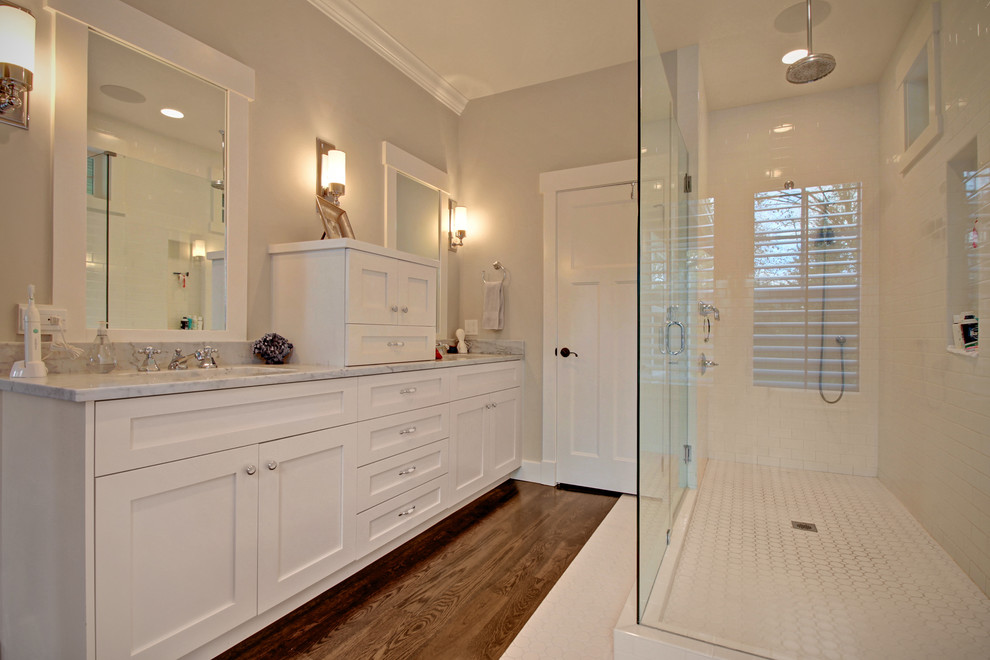 Inspiration for a mid-sized arts and crafts master bathroom in Seattle with an undermount sink, shaker cabinets, white cabinets, marble benchtops, a corner shower, white tile, grey walls and medium hardwood floors.