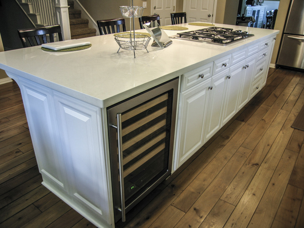 Open concept kitchen - mid-sized contemporary galley light wood floor open concept kitchen idea in Orange County with an undermount sink, raised-panel cabinets, white cabinets, quartzite countertops, green backsplash, stone slab backsplash, stainless steel appliances and an island