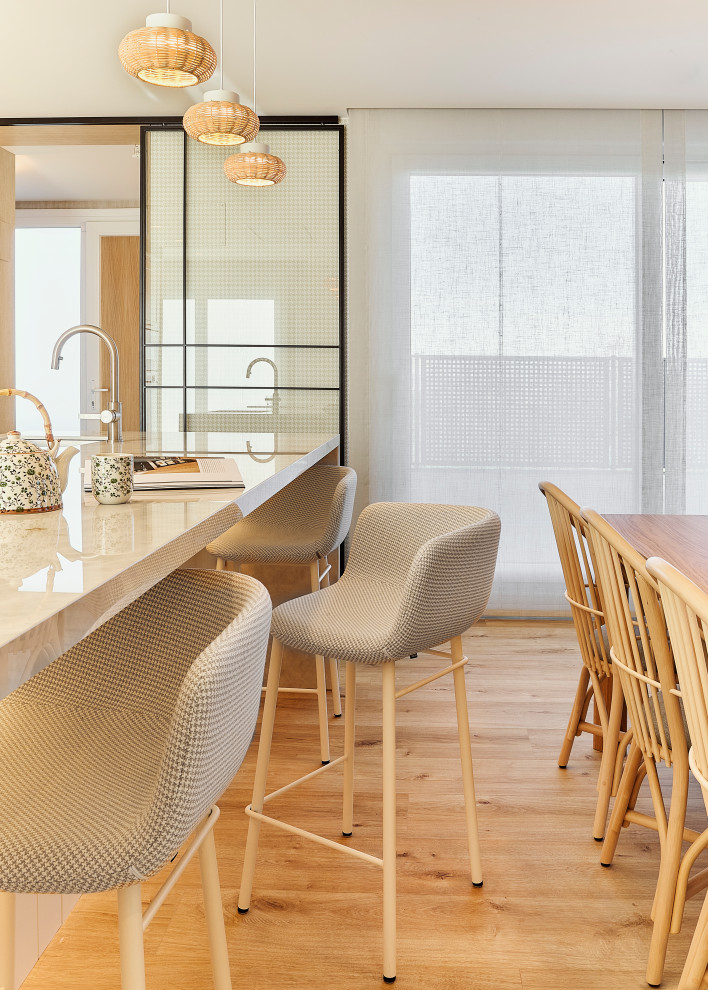 Modelo de comedor de cocina clásico renovado grande sin chimenea con paredes beige, suelo laminado, suelo marrón y papel pintado