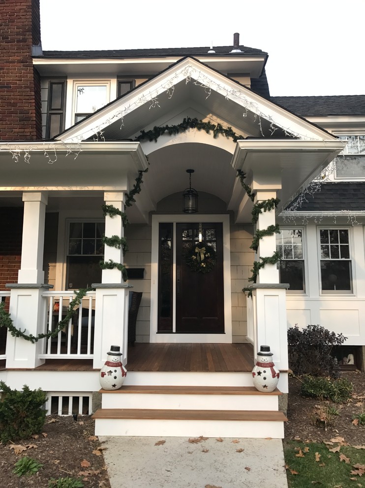 Mid-sized traditional front yard verandah in New York with a roof extension.