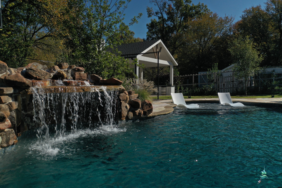 Inspiration for an expansive country backyard custom-shaped natural pool in Dallas with with privacy feature and natural stone pavers.