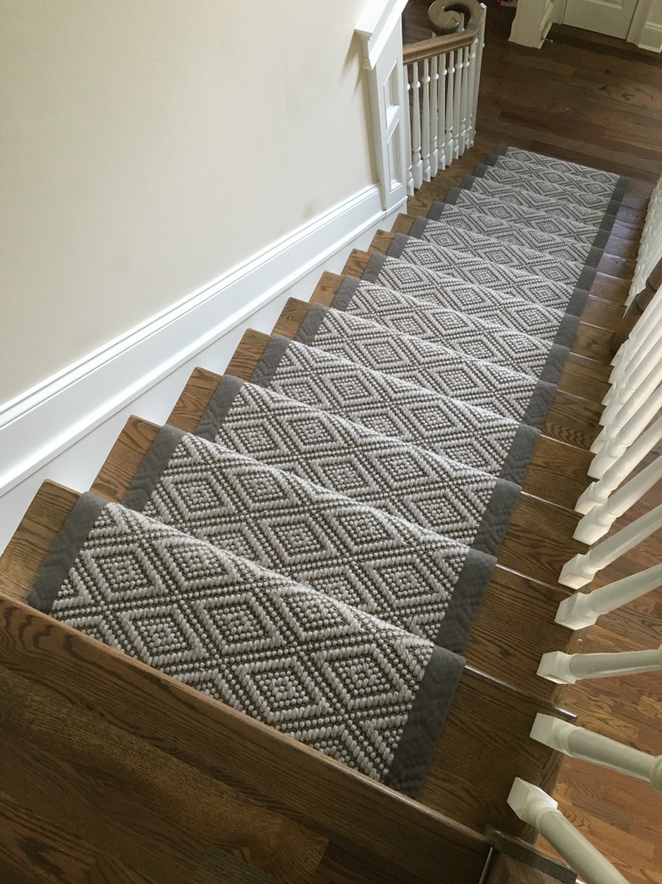 This is an example of a mid-sized transitional carpeted straight staircase in New York with carpet risers.