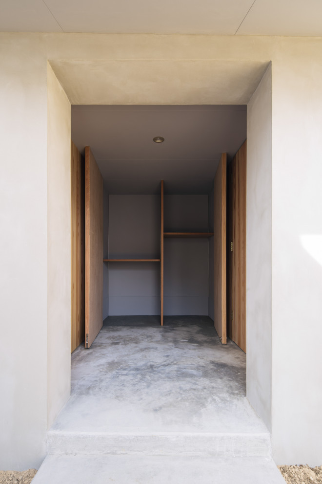 Foto de hall beige moderno con paredes beige, suelo de cemento, puerta simple, puerta de madera en tonos medios, suelo gris, machihembrado y boiserie