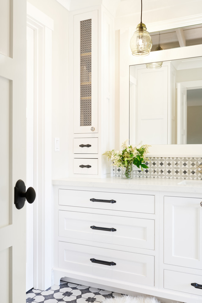 Photo of a mid-sized country bathroom in San Francisco with beaded inset cabinets, white cabinets, white tile, mosaic tile, ceramic floors, engineered quartz benchtops, black floor and white benchtops.