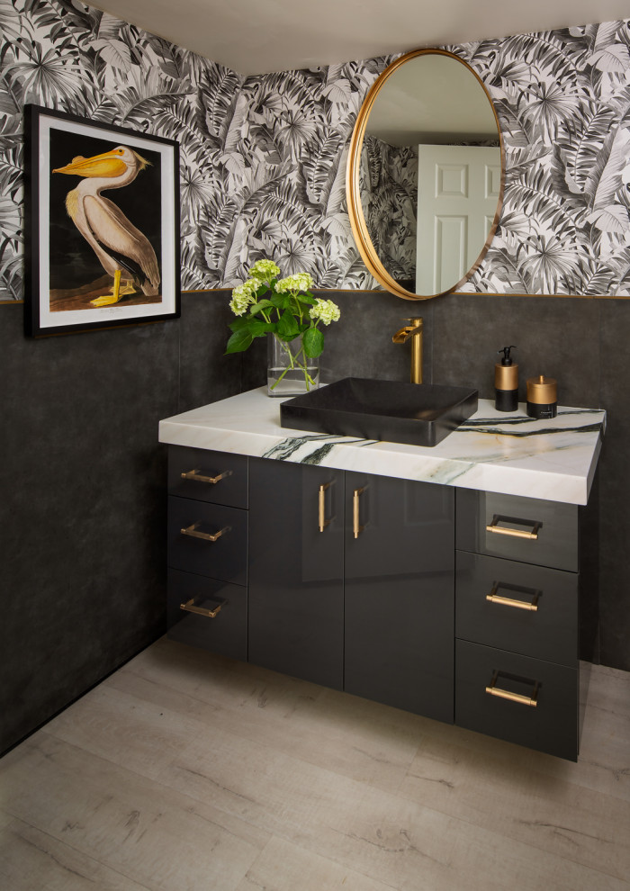 Inspiration for a mid-sized contemporary bathroom in San Diego with flat-panel cabinets, black cabinets, black walls, a vessel sink, engineered quartz benchtops, grey benchtops, an enclosed toilet, a single vanity and wallpaper.