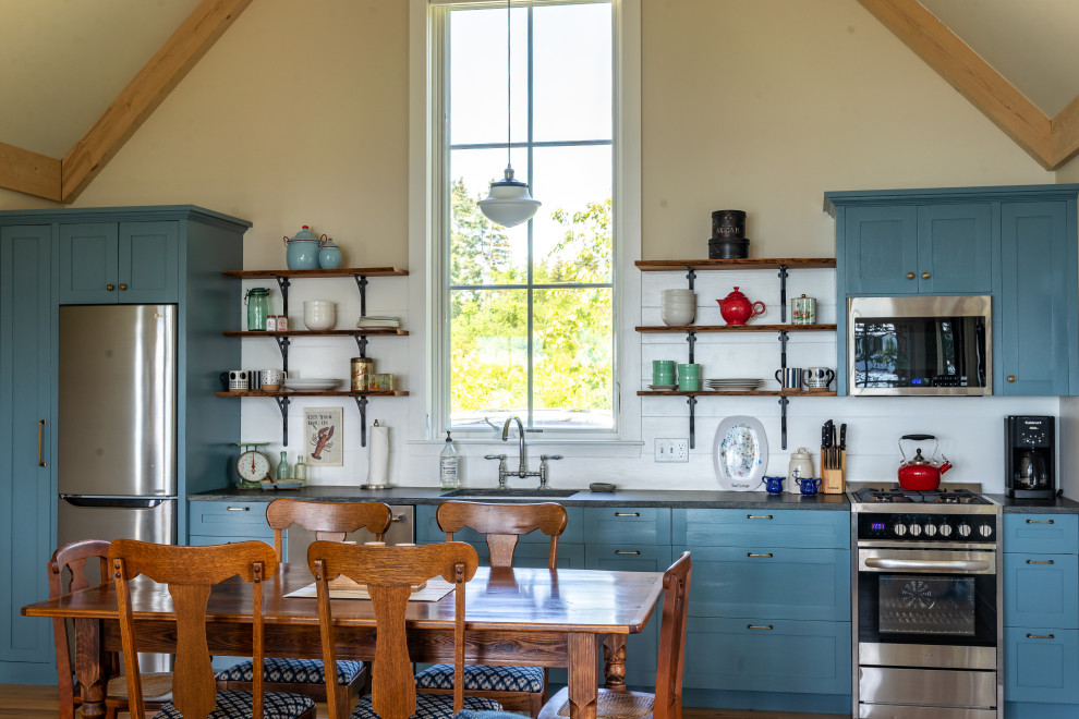 Inspiration for a country single-wall eat-in kitchen in Portland Maine with an undermount sink, shaker cabinets, blue cabinets, white splashback, shiplap splashback, stainless steel appliances, medium hardwood floors, green floor, grey benchtop, exposed beam and vaulted.