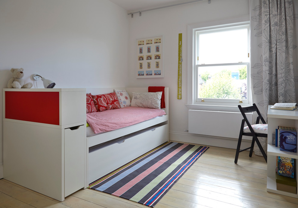 Photo of a scandinavian gender-neutral kids' room in London with white walls and painted wood floors.
