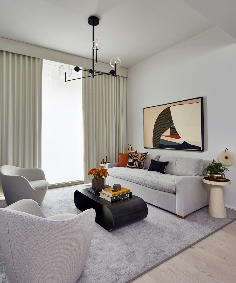This is an example of a mid-sized contemporary open concept living room in New York with white walls, light hardwood floors, no fireplace, a wall-mounted tv and beige floor.