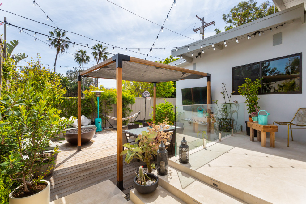 Mid-sized midcentury backyard patio in Los Angeles with a fire feature, decking and a gazebo/cabana.
