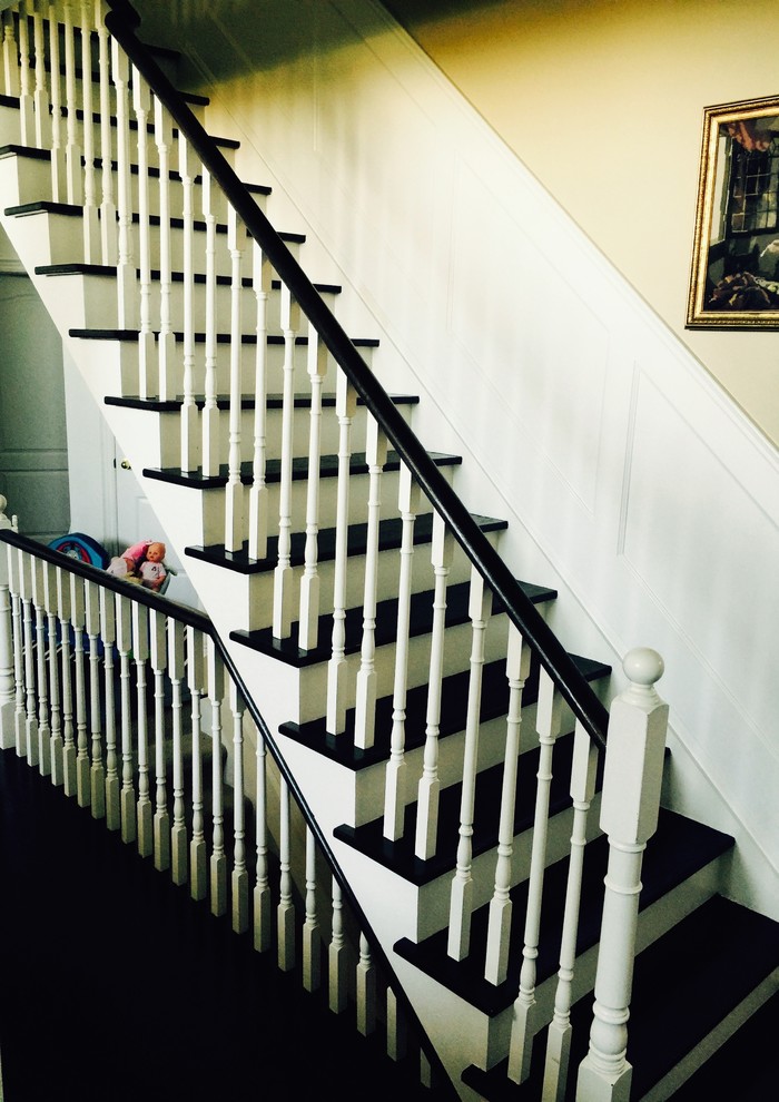 Large minimalist painted straight wood railing staircase photo in Toronto with painted risers