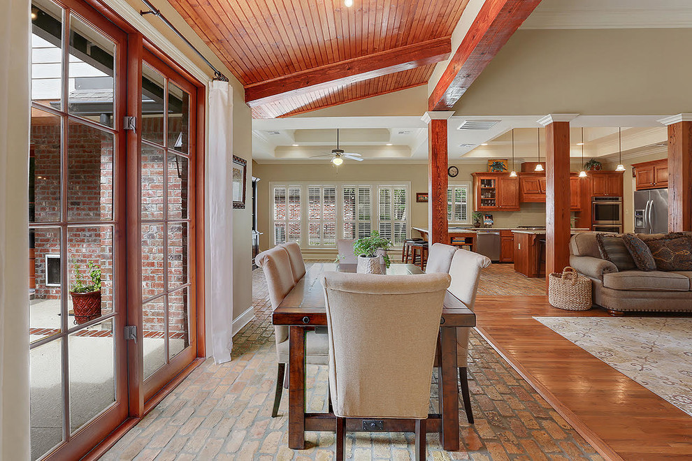 Design ideas for a mid-sized traditional open plan dining in New Orleans with beige walls and brick floors.