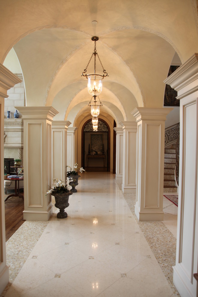 Large mediterranean hallway in Dallas with beige walls, marble floors, white floor, vaulted and wood walls.