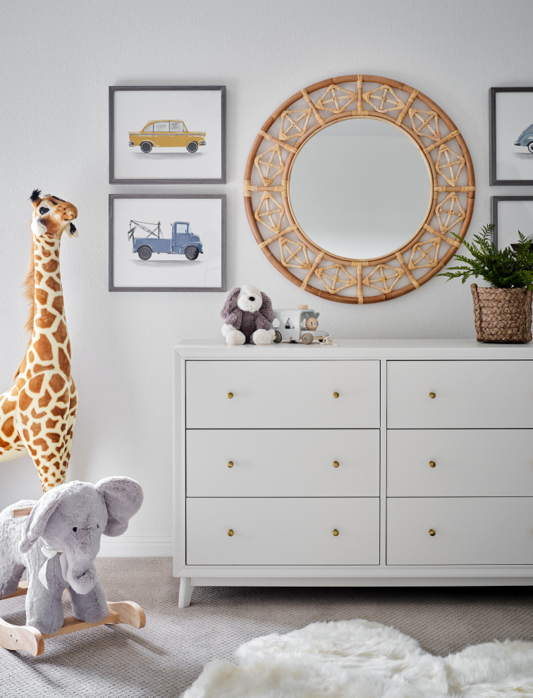 Belterra Project- Furnishings, Light Fixtures & Interior Design - In this the sweet nursery, the designer specified a blue gray paneled wall as the focal point behind the white and acrylic crib.  A comfortable cotton and linen glider and ottoman provide the perfect spot to rock baby to sleep.  A dresser with a changing table topper provides additional function, while adorable car artwork, a woven mirror, and a sheepskin rug add finishing touches and additional texture.