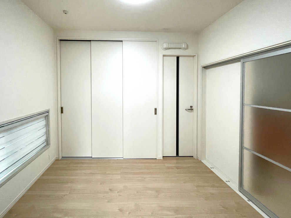 Photo of a medium sized modern gender neutral walk-in wardrobe in Other with white cabinets, beige floors, a wallpapered ceiling and light hardwood flooring.