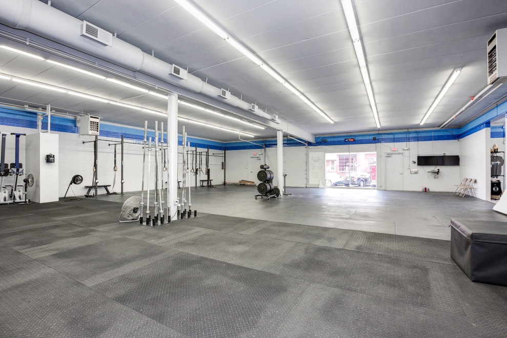 Expansive industrial multipurpose gym in DC Metro with white walls, cork floors and black floor.