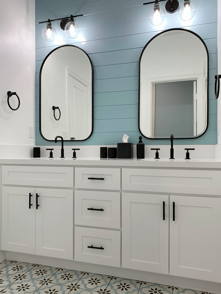 Small contemporary kids bathroom in Orange County with shaker cabinets, white cabinets, a drop-in tub, a shower/bathtub combo, a one-piece toilet, white tile, ceramic tile, blue walls, ceramic floors, an undermount sink, engineered quartz benchtops, multi-coloured floor, a sliding shower screen, white benchtops, a double vanity, a built-in vanity and planked wall panelling.