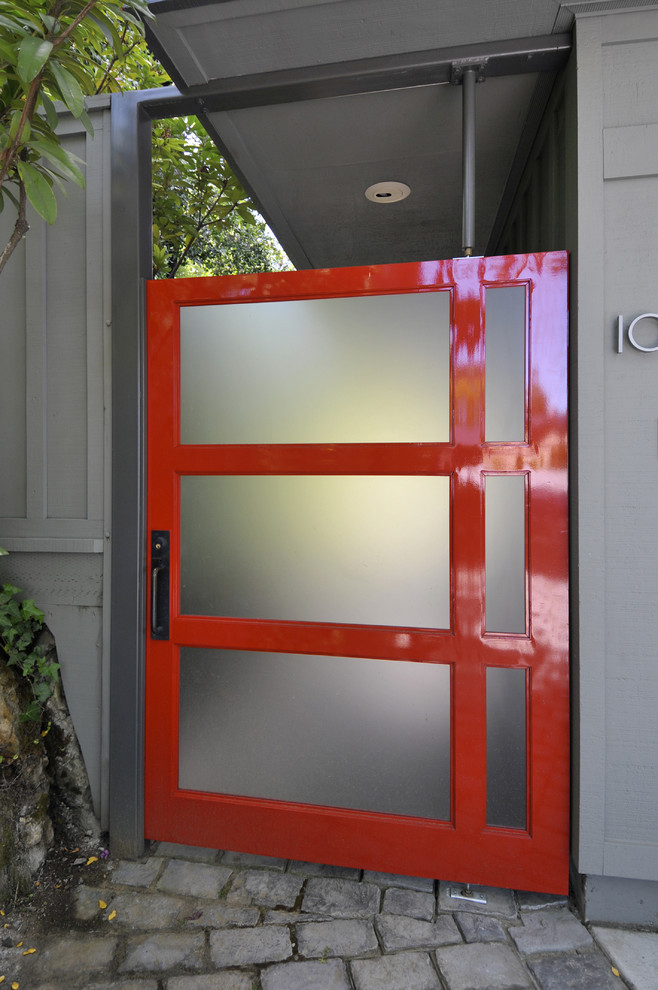 Photo of a contemporary front door in San Francisco with a pivot front door, a red front door and grey walls.
