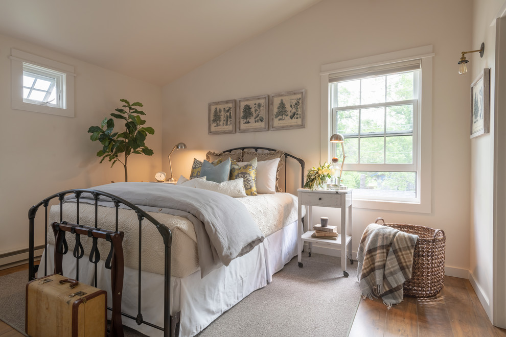 This is an example of a mid-sized transitional guest bedroom in Other with beige walls, medium hardwood floors, no fireplace and brown floor.