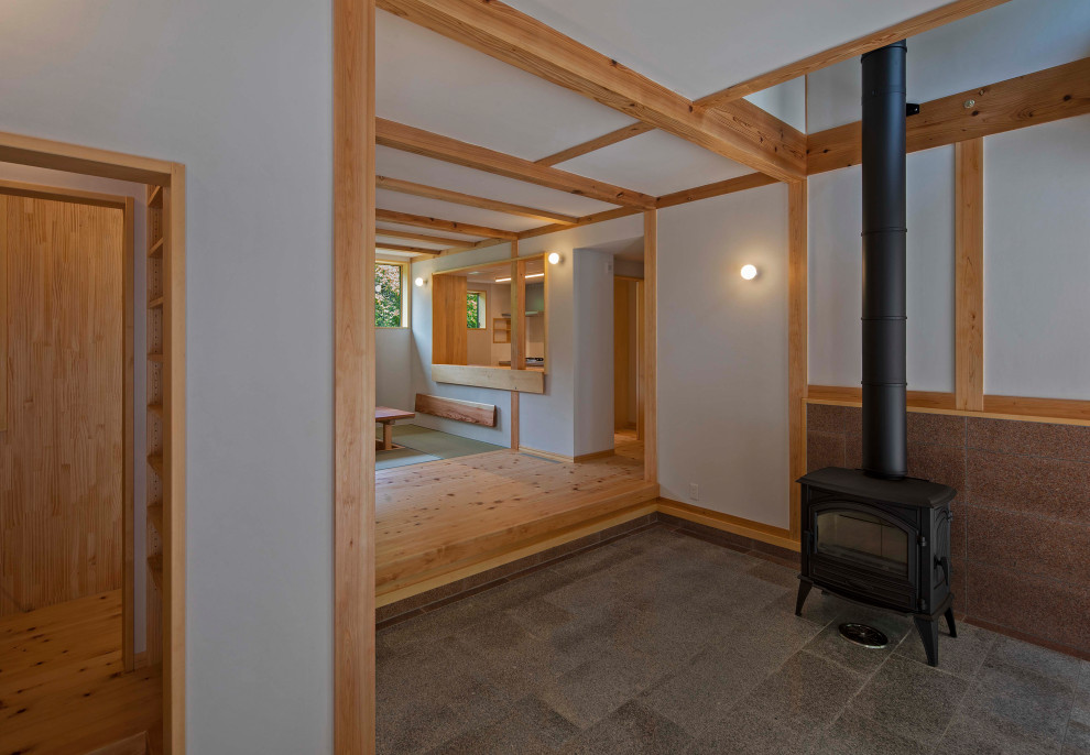 Photo of a small traditional hallway in Other with white walls, granite flooring, a sliding front door, a light wood front door, grey floors, exposed beams and wood walls.