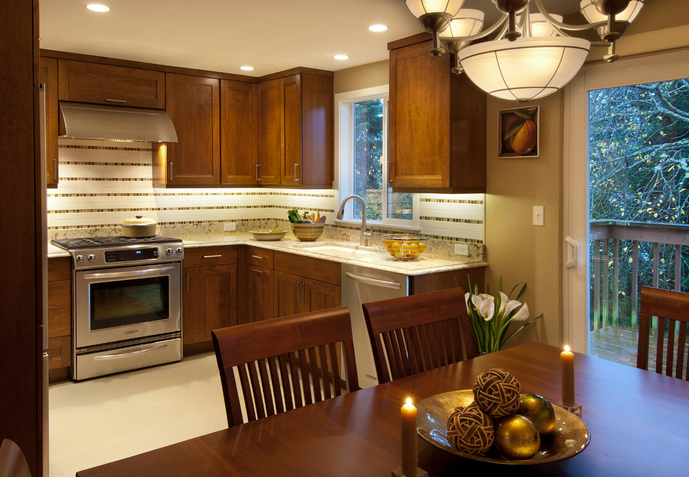 This is an example of a small transitional u-shaped separate kitchen in Seattle with an undermount sink, recessed-panel cabinets, dark wood cabinets, quartz benchtops, beige splashback, cement tile splashback, stainless steel appliances, porcelain floors and no island.