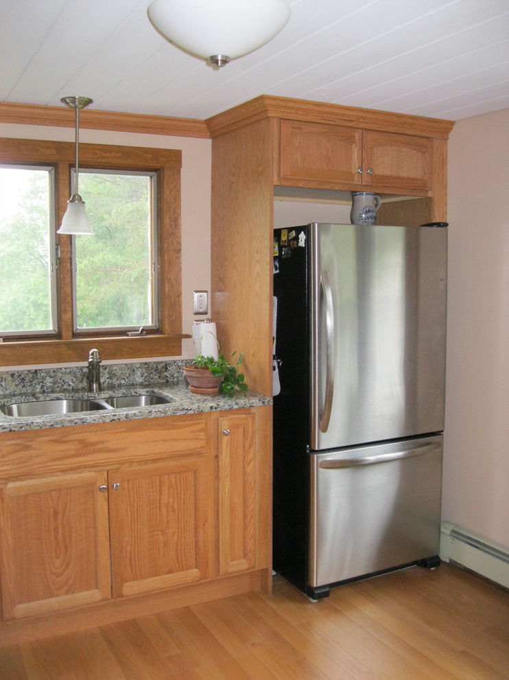 Kitchen - mid-sized transitional l-shaped light wood floor kitchen idea in Boston with flat-panel cabinets, light wood cabinets, granite countertops, stainless steel appliances, a peninsula and an undermount sink