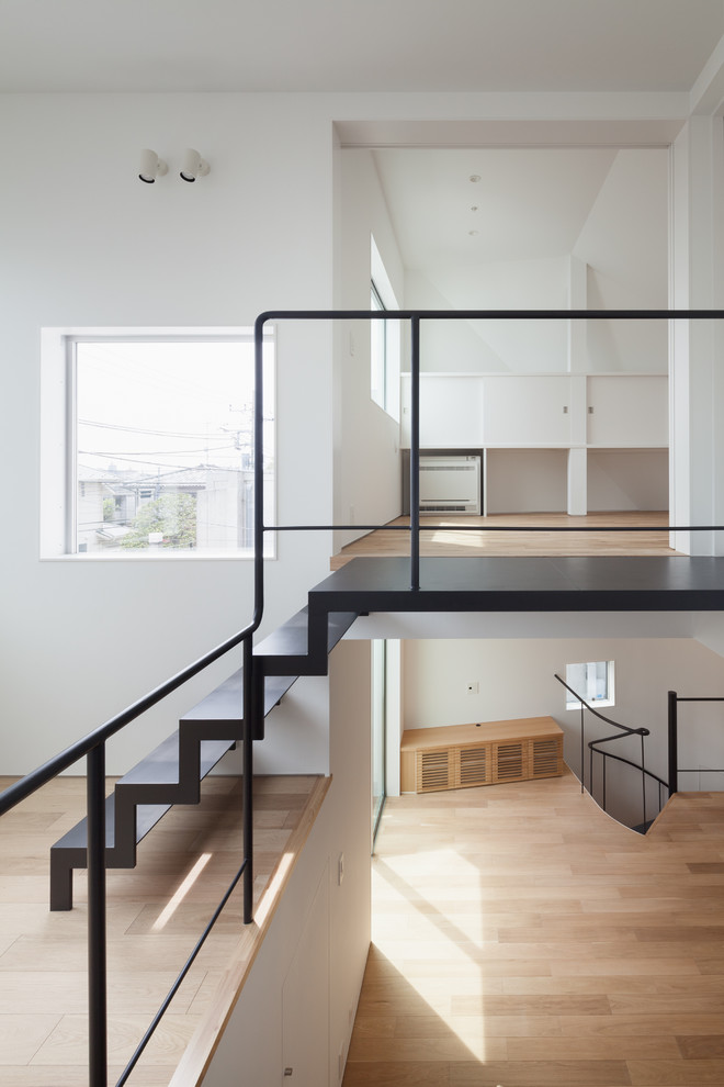 Modern metal straight staircase in Tokyo with open risers and metal railing.