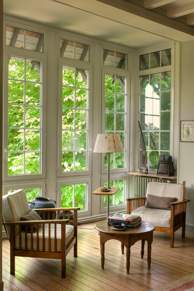 Inspiration for a mid-sized traditional sunroom in Paris with medium hardwood floors, a standard ceiling and no fireplace.