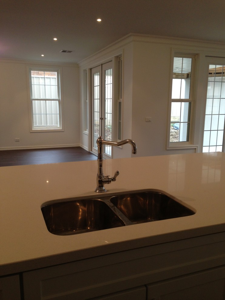 This is an example of a large transitional galley eat-in kitchen in Melbourne with a double-bowl sink and with island.