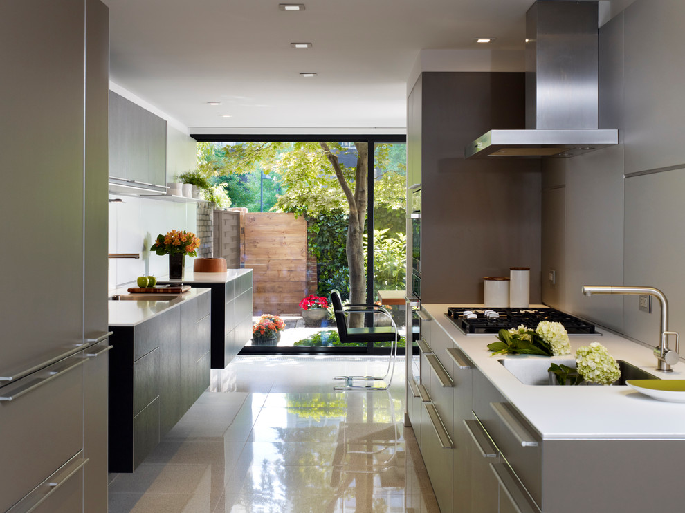 Design ideas for a contemporary galley eat-in kitchen in Philadelphia with flat-panel cabinets, an undermount sink, quartz benchtops, grey splashback, panelled appliances and porcelain floors.