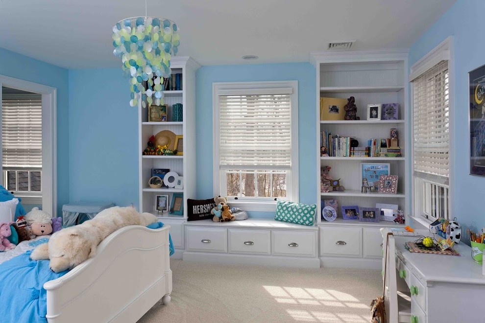 This is an example of a transitional kids' bedroom for girls in Other with blue walls and carpet.