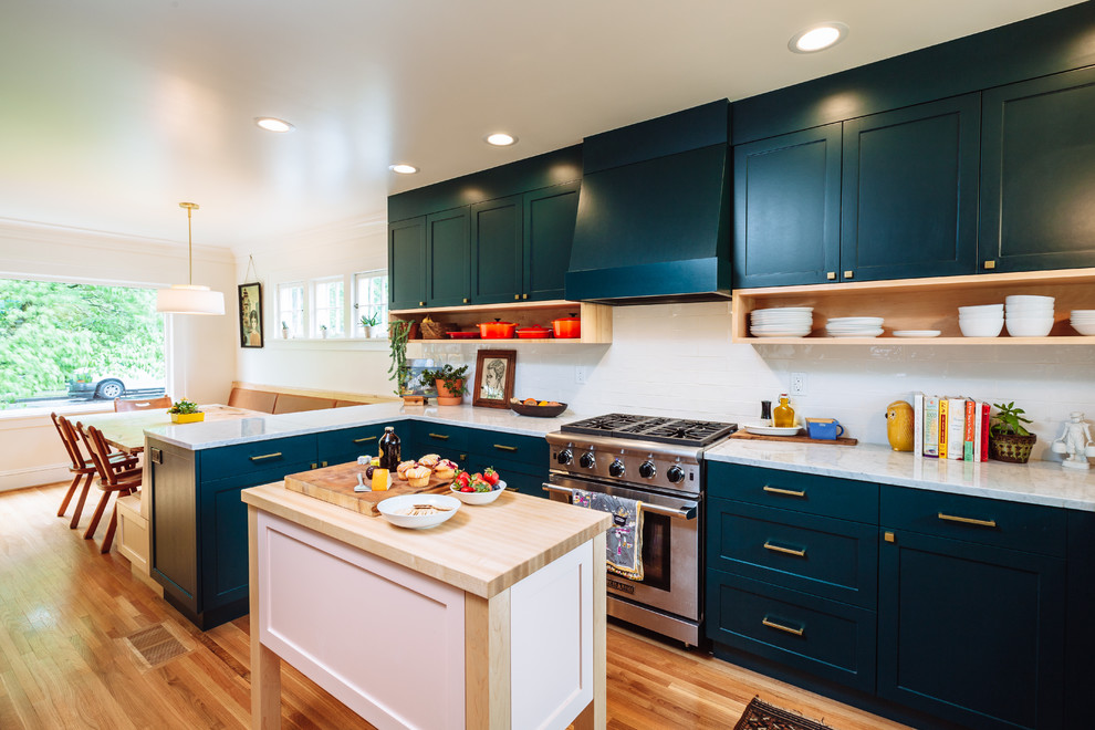 Mid-sized transitional u-shaped eat-in kitchen in Portland with a single-bowl sink, shaker cabinets, green cabinets, marble benchtops, white splashback, ceramic splashback, panelled appliances, light hardwood floors, with island and brown floor.