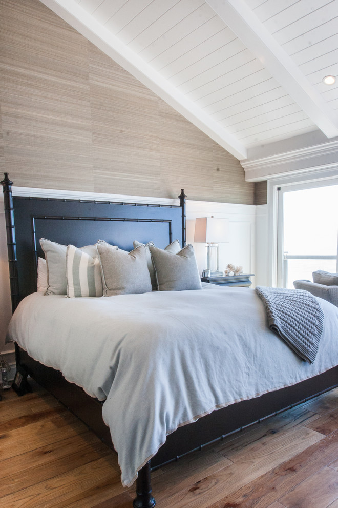 Beach style master bedroom in Orange County with beige walls and medium hardwood floors.
