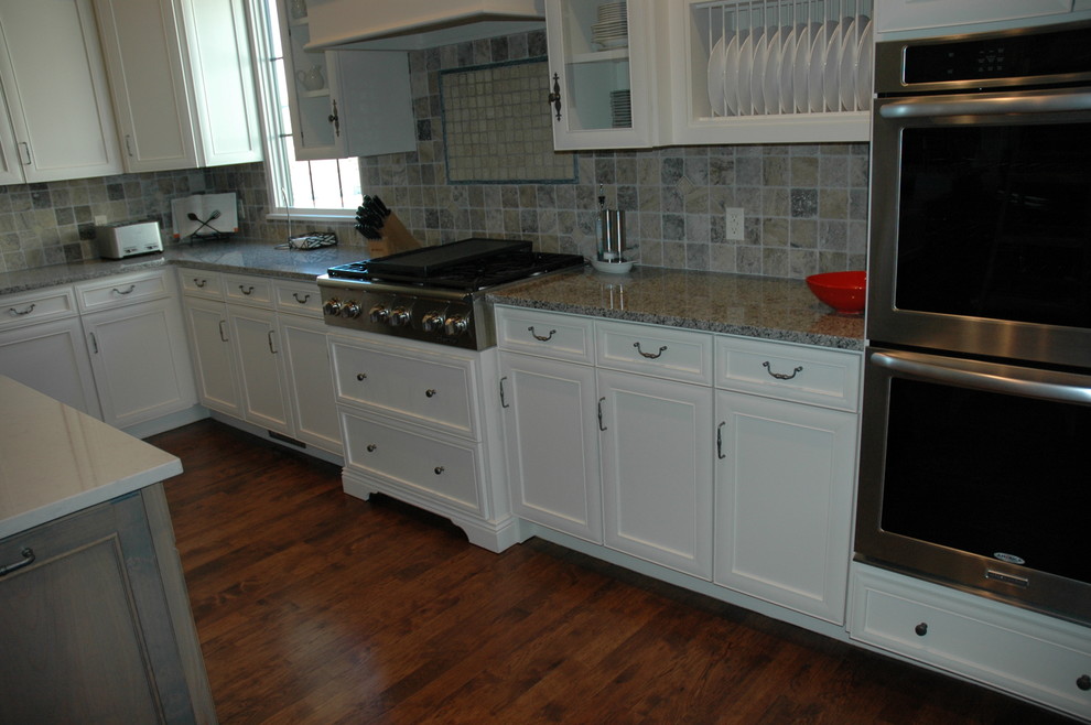 Inspiration for a large transitional u-shaped medium tone wood floor kitchen pantry remodel with a farmhouse sink, flat-panel cabinets, yellow cabinets, laminate countertops, brown backsplash, stone tile backsplash, paneled appliances and an island