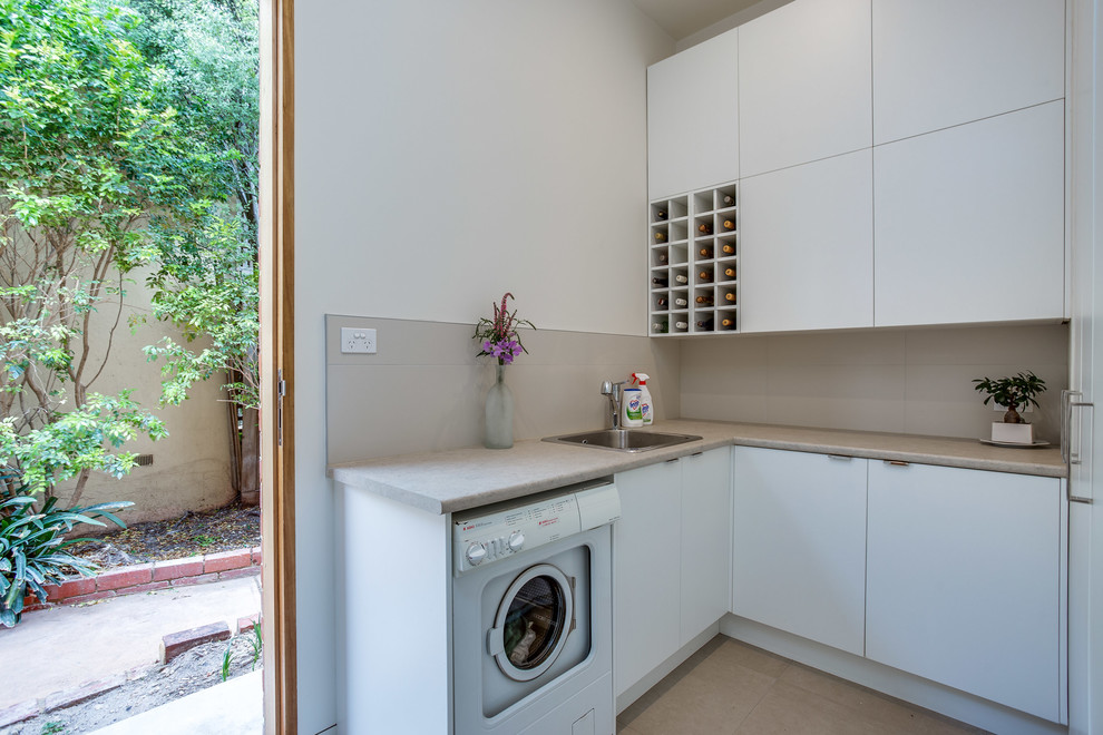 Inspiration for a mid-sized contemporary l-shaped dedicated laundry room in Melbourne with white cabinets, porcelain floors and flat-panel cabinets.