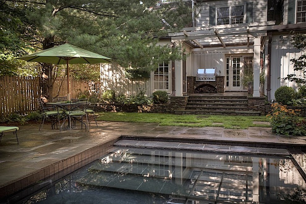Example of a large transitional backyard stone and l-shaped natural pool house design in Toronto