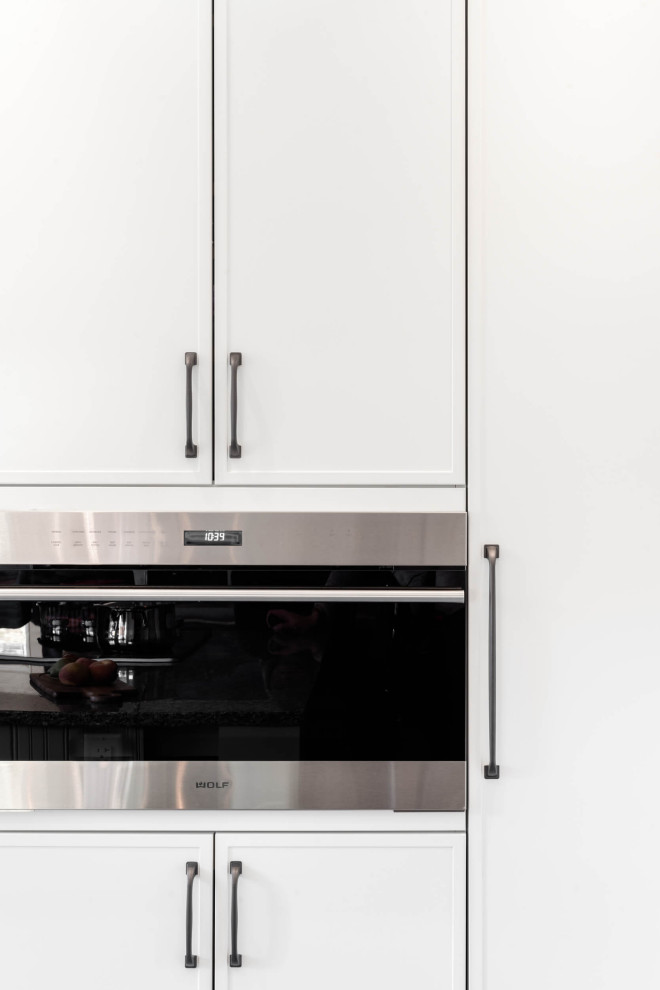 Example of a mid-sized transitional galley eat-in kitchen design with shaker cabinets and an island