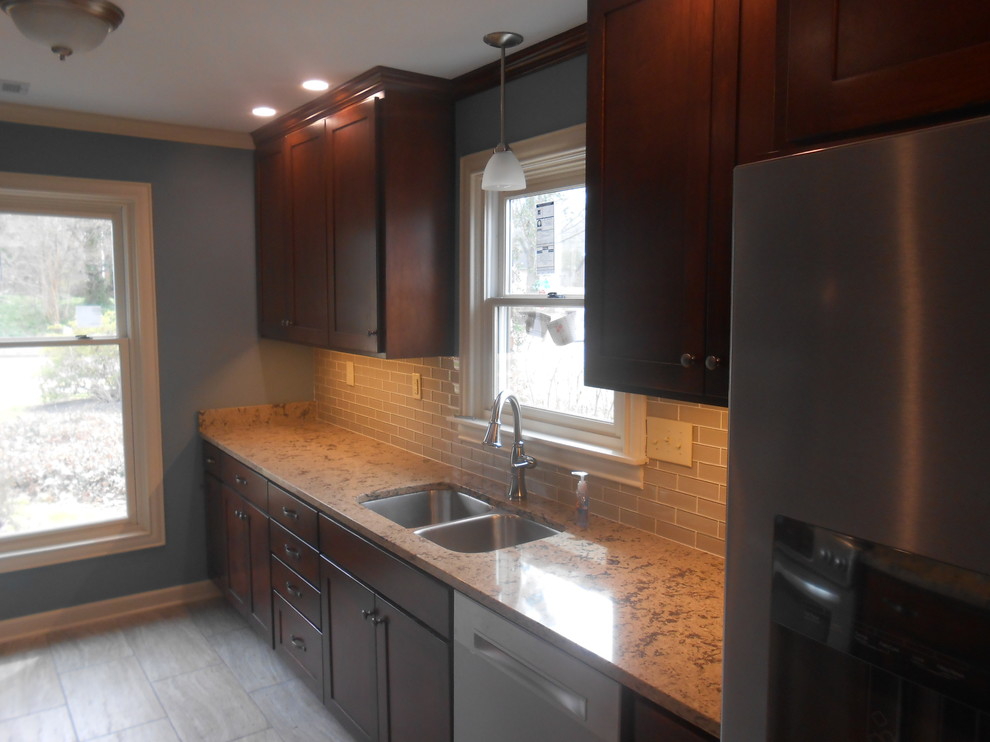 Eat-in kitchen - mid-sized transitional galley porcelain tile eat-in kitchen idea with an undermount sink, shaker cabinets, dark wood cabinets, quartz countertops, beige backsplash, glass sheet backsplash, stainless steel appliances, blue walls and no island