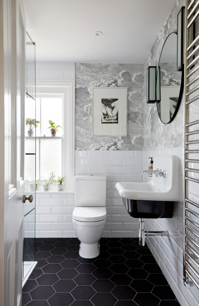 Example of a mid-sized ornate white tile and ceramic tile ceramic tile, black floor and wallpaper powder room design in Surrey with open cabinets, black cabinets, a one-piece toilet, multicolored walls, tile countertops and a floating vanity