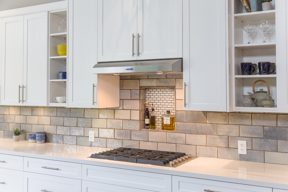 Inspiration for a mid-sized modern l-shaped eat-in kitchen with an undermount sink, shaker cabinets, white cabinets, quartz benchtops, grey splashback, subway tile splashback, stainless steel appliances, medium hardwood floors, with island and white benchtop.