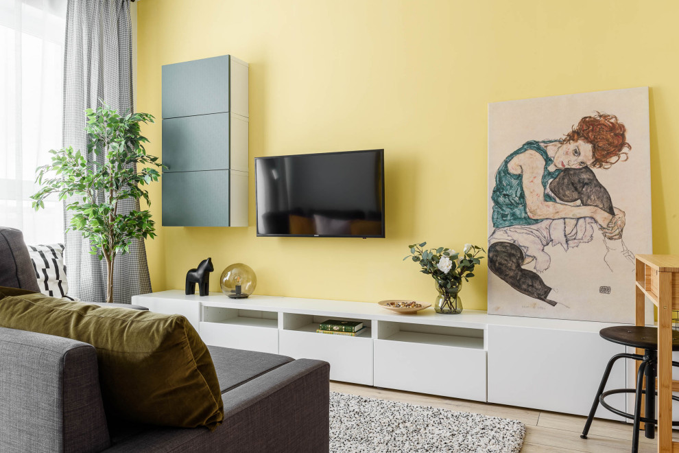 Aménagement d'un salon contemporain avec un mur jaune, parquet clair, un téléviseur fixé au mur et un sol beige.