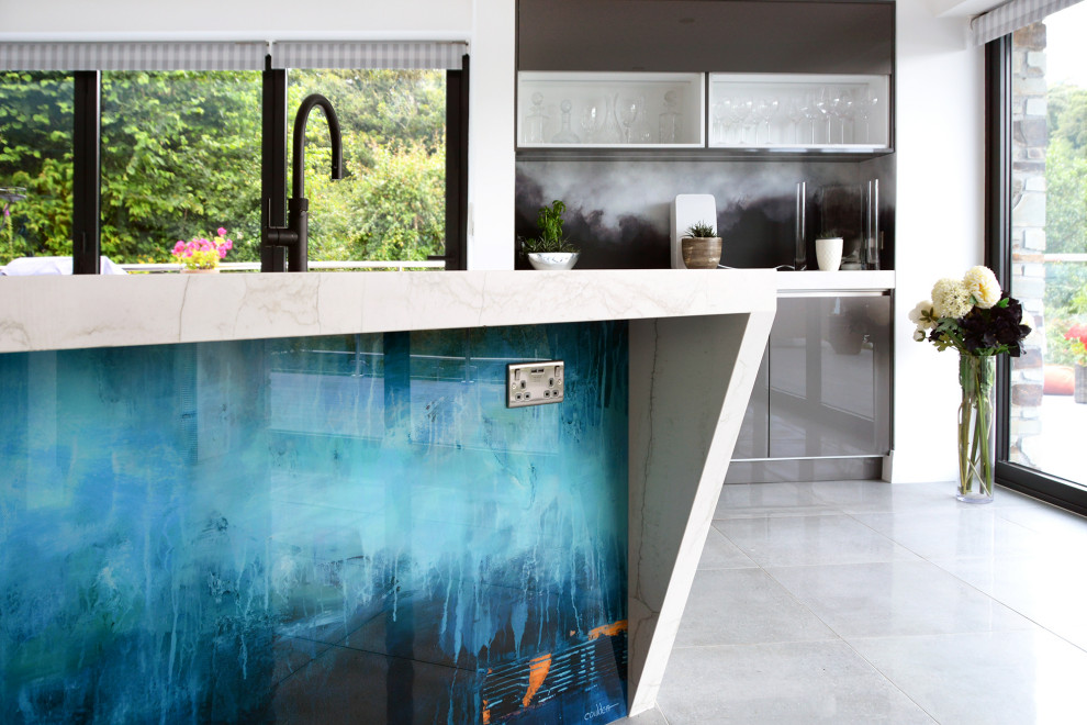 Foto di un'ampia cucina minimalista con ante lisce, ante grigie, top in quarzo composito, paraspruzzi blu, paraspruzzi con lastra di vetro e top bianco