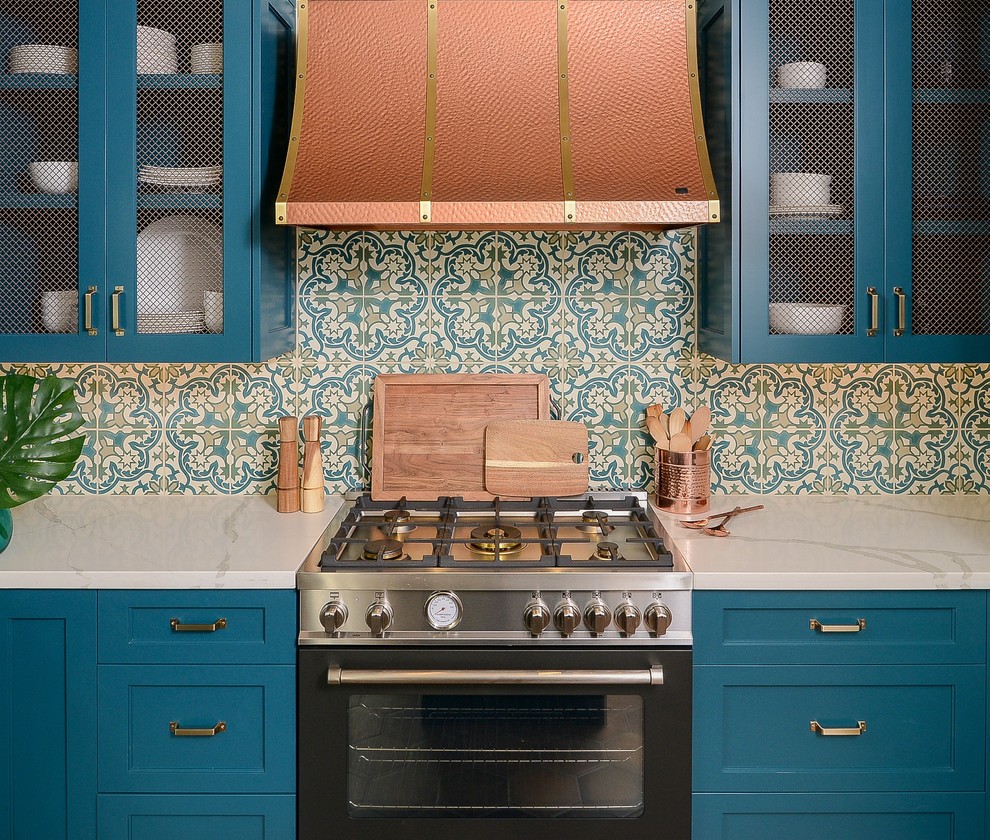 Mediterranean kitchen in Sacramento with shaker cabinets, turquoise cabinets, solid surface benchtops, terra-cotta floors, with island and white benchtop.