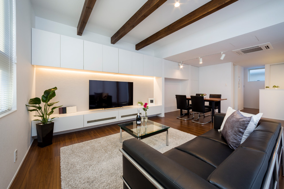 Contemporary open concept living room in Other with white walls, medium hardwood floors, a freestanding tv and brown floor.