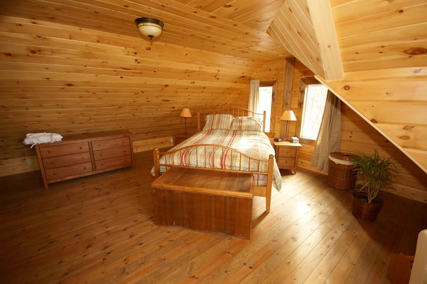 Photo of a country bedroom in Charlotte with dark hardwood floors.