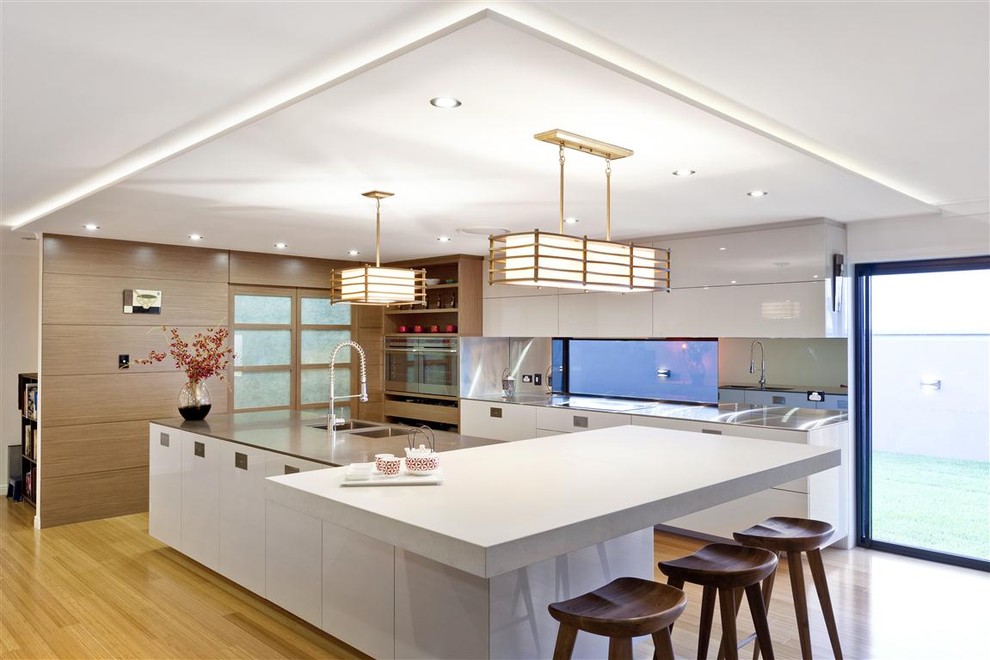 This is an example of a contemporary kitchen in Brisbane with stainless steel appliances and white benchtop.