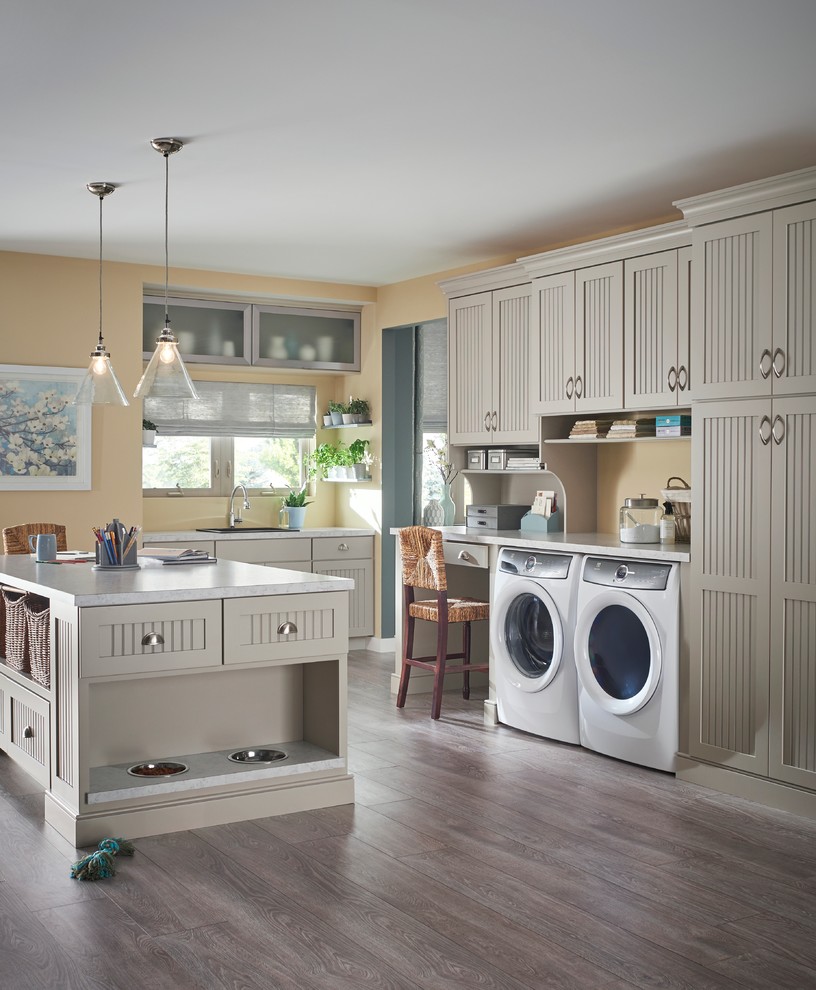 This is an example of a transitional utility room in Minneapolis with a drop-in sink, dark hardwood floors, a side-by-side washer and dryer, recessed-panel cabinets, grey cabinets and beige walls.